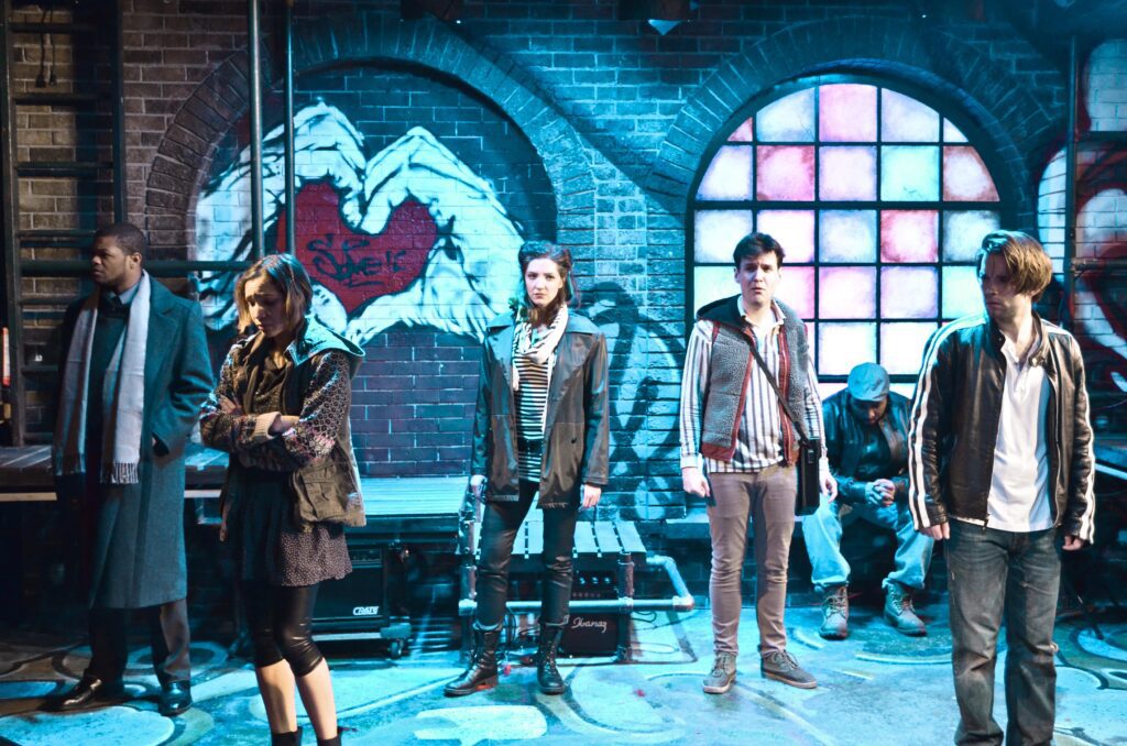 Scene from Rent with multiple characters spreading across stage