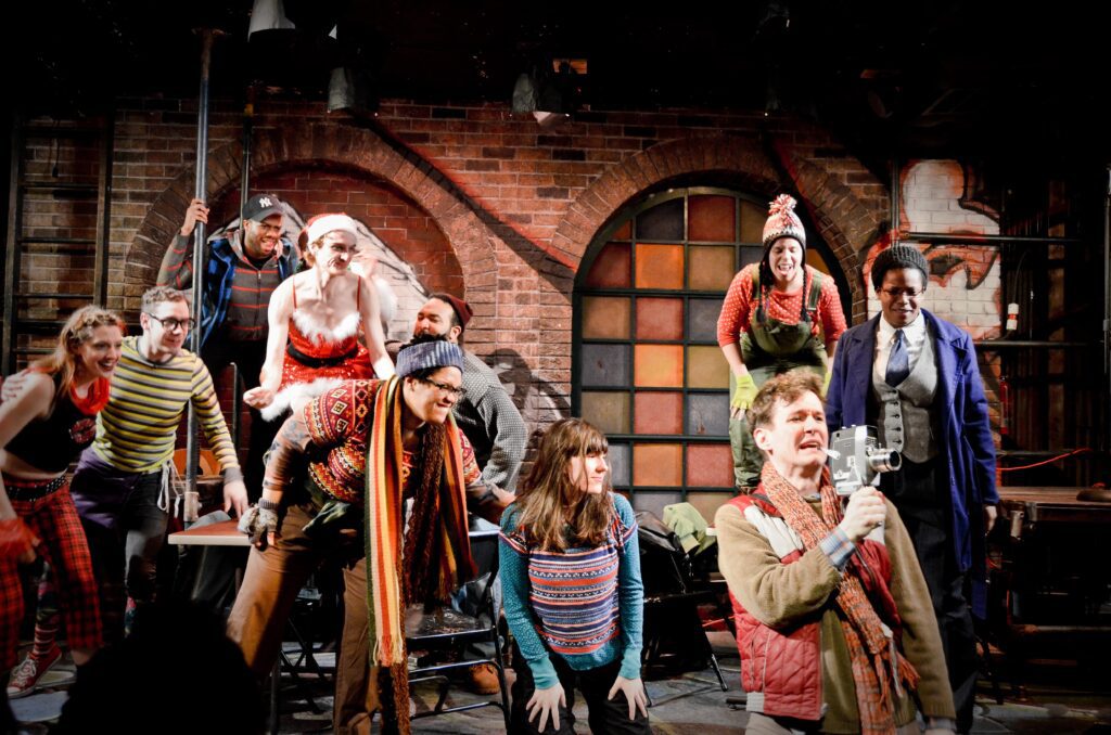 Large group of characters from Rent singing together